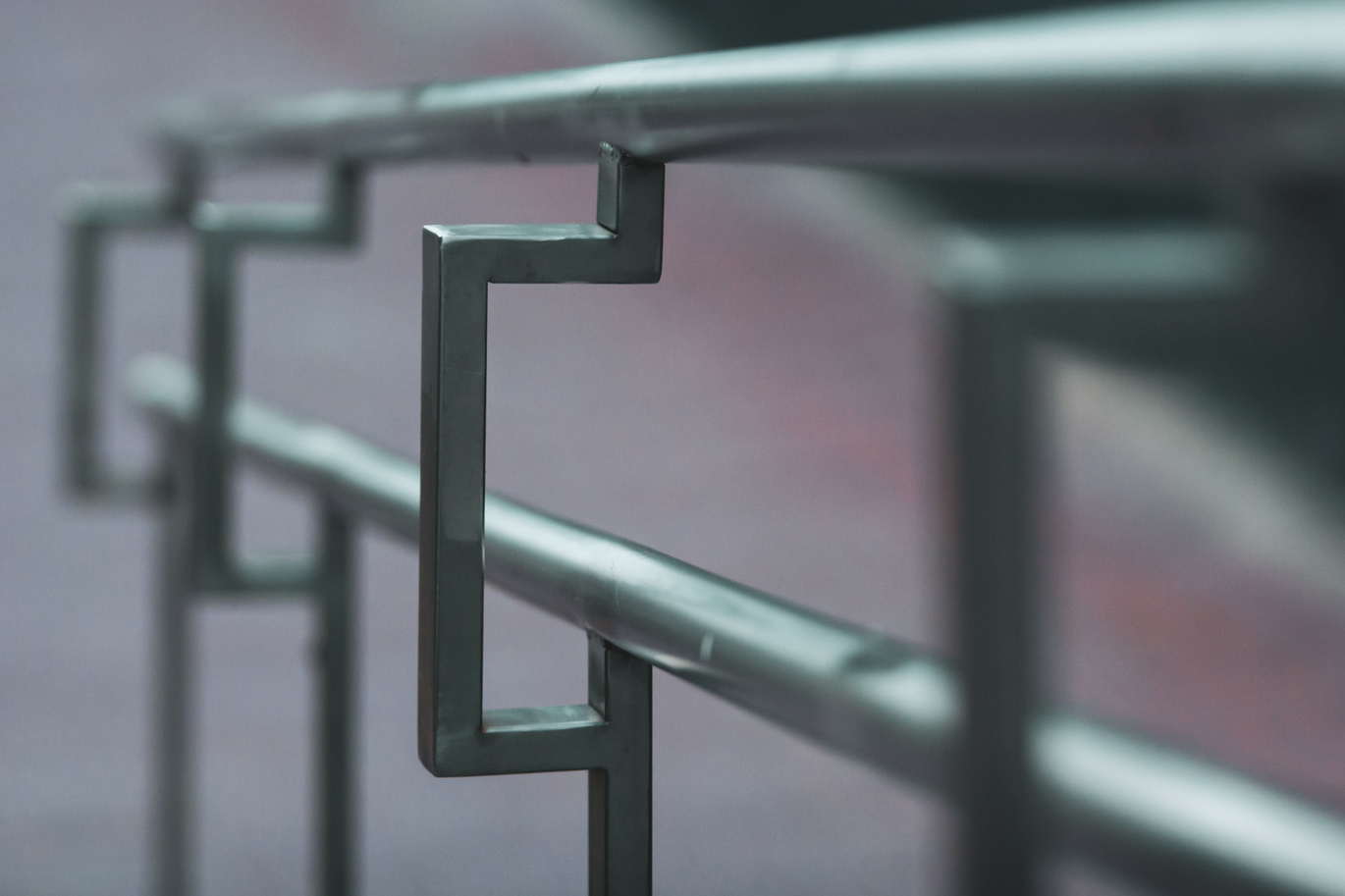Stainless steel handrails on the street receding into the distance with selective focus.